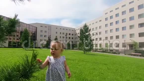 慢动作特写可爱的女婴在城市公园散步在她身边探索世界夏天阳光明媚的一天视频的预览图