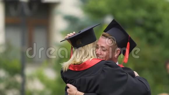 快乐的一对毕业生英俊的男人拥抱和旋转美丽的女人视频的预览图