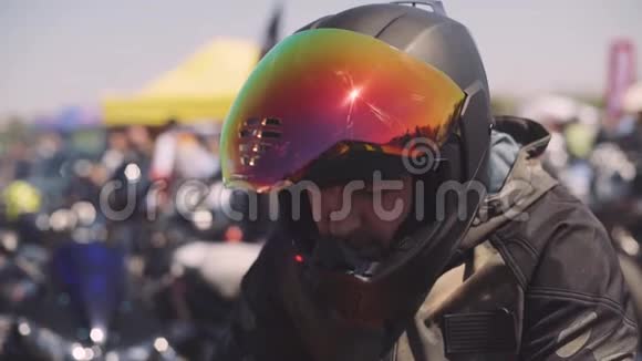 街上日落时分一个戴黑色头盔的摩托车手的肖像彩色面罩视频的预览图