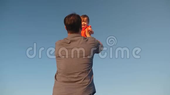 爸爸把女儿抛在蓝天上爸爸和一个小孩子玩幸福的家庭晚上在天空中玩耍视频的预览图