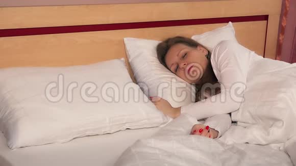 男人的丈夫把郁金香花放在枕头上靠近熟睡的女人躺在床上视频的预览图