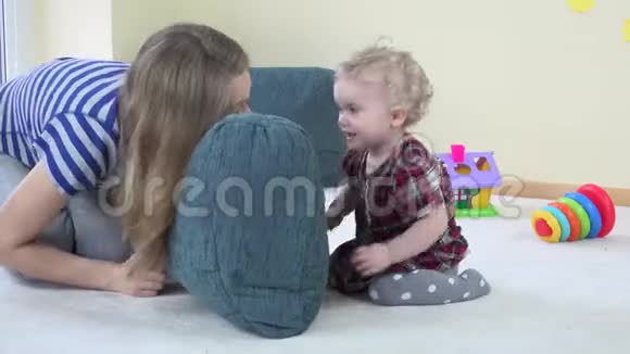 妈妈和蹒跚学步的孩子玩蓝色的大枕头展示真实的情感视频的预览图