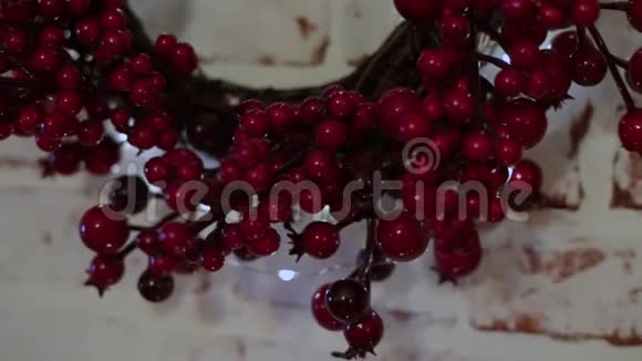 一个红色浆果的花环挂在白色的墙上视频的预览图