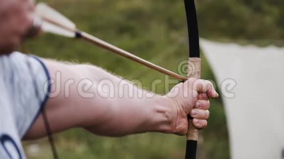 一个人在田野里从弓中射出一支箭有一艘古老的西塞斯飞船在一个背景视频的预览图