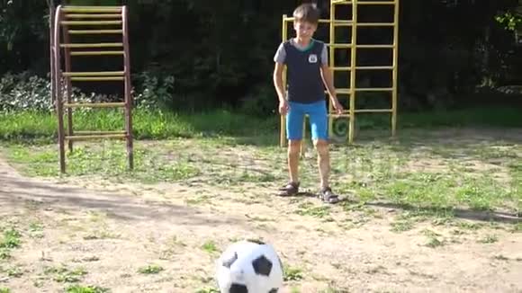男孩在操场上慢动作踢球视频的预览图