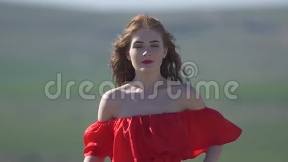 一个穿着猩红裙子光着肩膀的奢华女人的肖像视频的预览图
