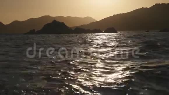 日落时山峦岩石和平静的大海视频的预览图