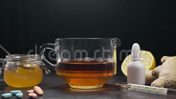 在杯子里加入了蜂蜜和红茶柠檬茶和蜂蜜还有药片和温度计视频的预览图