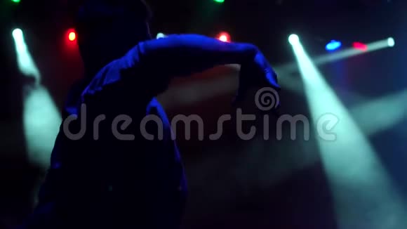 一个年轻人在黑暗中用聚光灯跳舞视频的预览图