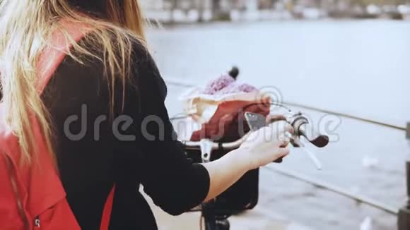 创意女商人在桥上拍照骑自行车的时尚女士拍摄美丽的河城风景4K视频的预览图
