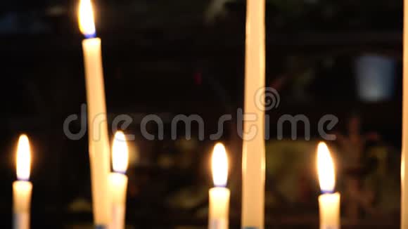 在黑暗背景下的寺庙里点燃白色蜡烛视频的预览图