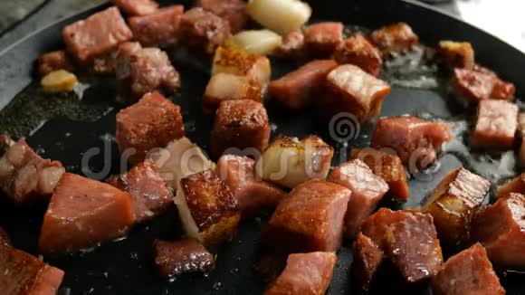 烹饪美味的热食切丁脆皮香肠和培根在厨房的平底锅里用滚烫的脂肪油炸视频的预览图
