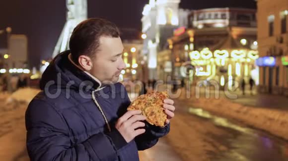 年轻人喜欢街头美食晚上在城市背景下吃披萨视频的预览图
