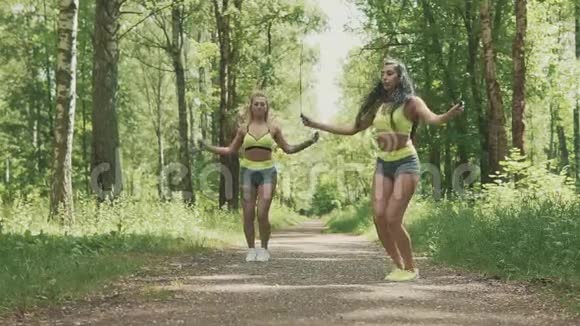 两个年轻的女人在公园里缓慢地跳绳健康生活方式视频的预览图