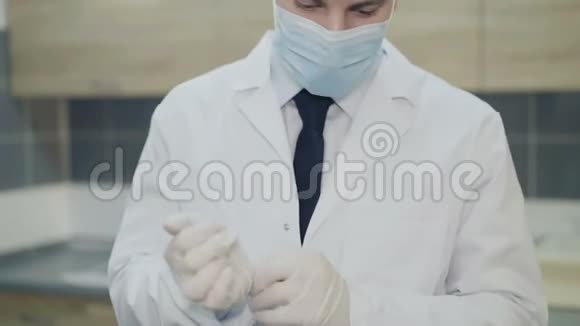 年轻疲惫的医生戴上面具对着镜头轻轻微笑视频的预览图