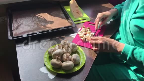 一个女人正在切切割板上的香槟奶酪放在盘子旁边视频的预览图