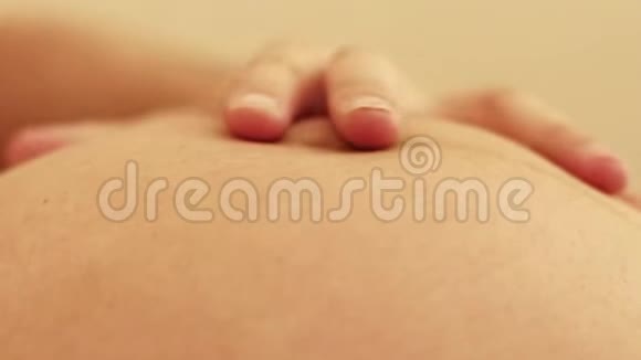 男性手在怀孕的陶米怀孕夫妇爱抚怀孕的肚皮视频的预览图