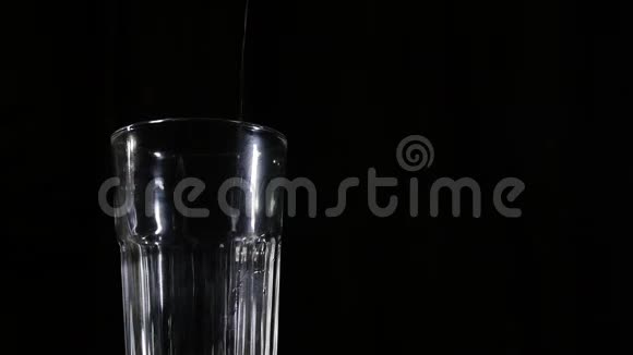 将樱桃汁倒入黑色背景的玻璃杯中视频的预览图