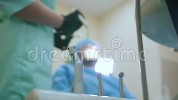 牙科办公室的医生和病人治疗过程设备和工具在前景视频的预览图