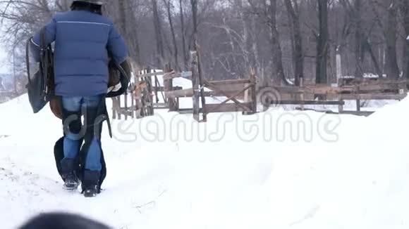 农场里的骑手在骑马前准备好马鞍她的狗到处跑视频的预览图