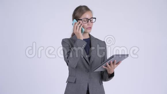 年轻快乐的女商人在电话里用数码平板电脑视频的预览图