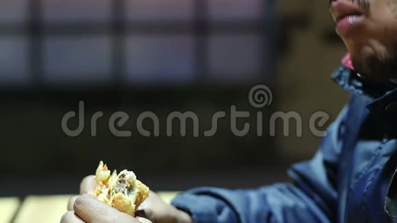 懒惰的年轻人嚼着油腻的三明治垃圾食品成瘾者体重增加视频的预览图