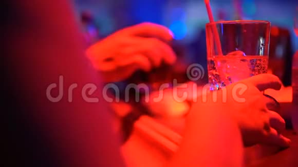 女性喝鸡尾酒在酒吧柜台和朋友聊天特写视频的预览图