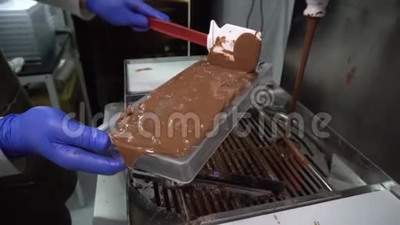 制作巧克力的过程工厂工人用融化的巧克力填充模具视频的预览图
