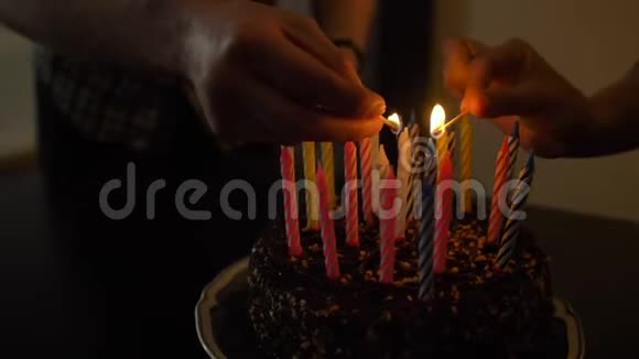 女人和男人在美味的生日蛋糕上点燃蜡烛准备参加派对视频的预览图