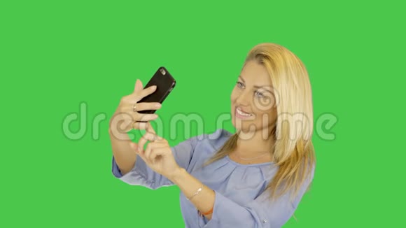金发女郎用智能手机自拍高加索女孩在智能手机上拍照透明Alpha通道视频的预览图