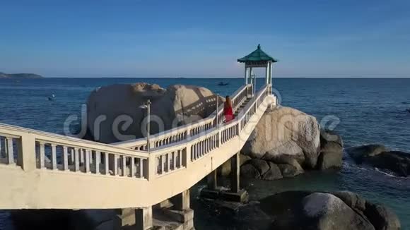 女人上楼梯到海边的岩石上的海湾视频的预览图
