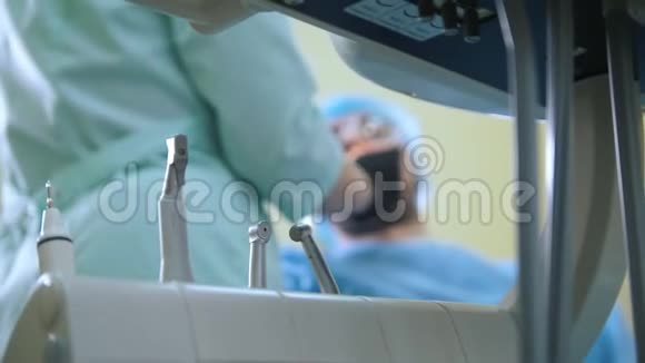牙科办公室的模糊医生和病人前台的医疗器械和演练视频的预览图
