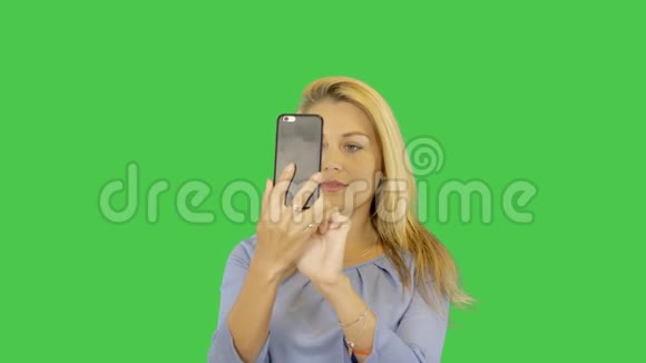 白色金发女孩微笑并在智能手机上拍照自拍阿尔法通道透明背景视频的预览图
