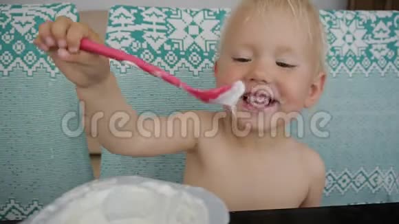宝宝吃酸奶弄得一团糟笑起来的蓝眼睛小女孩吃酸奶视频的预览图