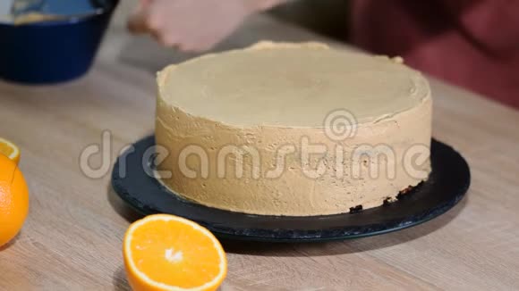 厨师把蛋糕层贴在奶油上烹饪分层蛋糕做分层馅饼巧克力蛋糕层视频的预览图