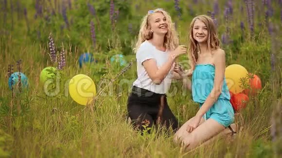 两个少女最好的朋友坐在草地上拥抱视频的预览图