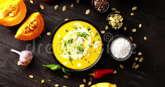 鲜黄的南瓜汤被香料和种子包围视频的预览图