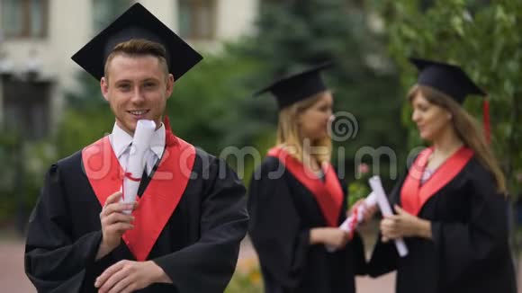 英俊的男毕业生张开双臂为相机微笑幸福的未来视频的预览图