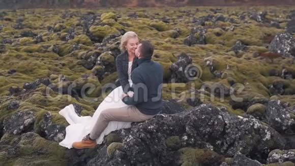 一对年轻夫妇拥抱在大自然的岩石上视频的预览图