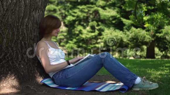 坐在公园里看书的女孩视频的预览图