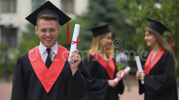 快乐的男毕业生手里拿着文凭微笑着快乐的时刻视频的预览图