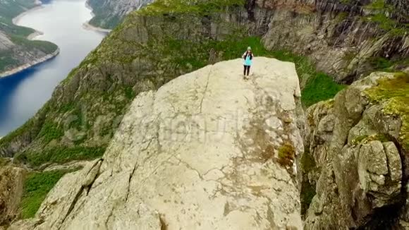 挪威岩石边缘的女孩空中VIE视频的预览图