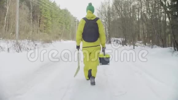 穿着运动服的生态学家在冬季森林的道路上行走视频的预览图
