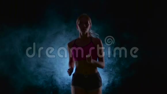跑步运动女孩前景烟雾中的黑色屏幕剪影慢动作关门视频的预览图