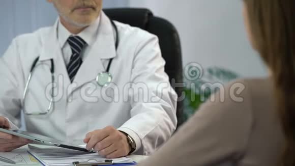 医生与病人交谈并检查他的平板电脑上的病历视频的预览图