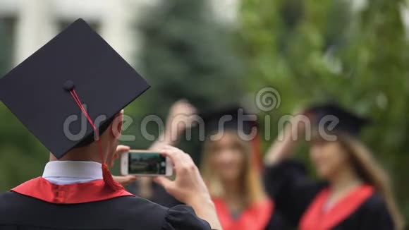 最好的朋友毕业生摆姿势拍照把毕业帽扔到空中视频的预览图