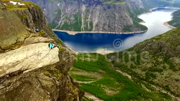 挪威岩石边缘的女孩空中VIE视频的预览图