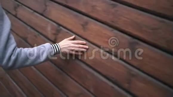 女性手触摸一堵木墙视频的预览图