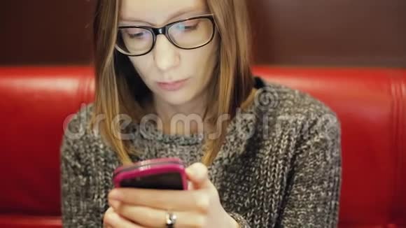 戴眼镜的漂亮女人在手机上发短信美丽的年轻休闲女学生视频的预览图