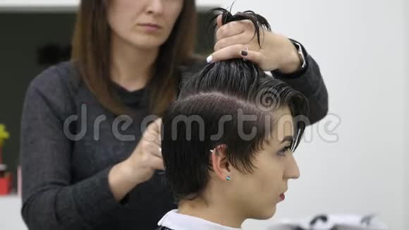 专业美发师发型师在专业美发店梳理女性客户头发美容和理发的概念视频的预览图